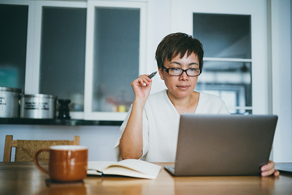 Senior woman works on her laptop at home